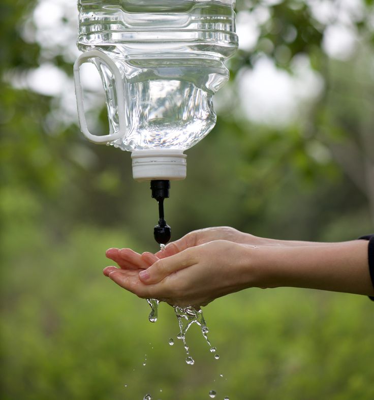 Hang a container with a spigot from a tree to set up a hand-wash station