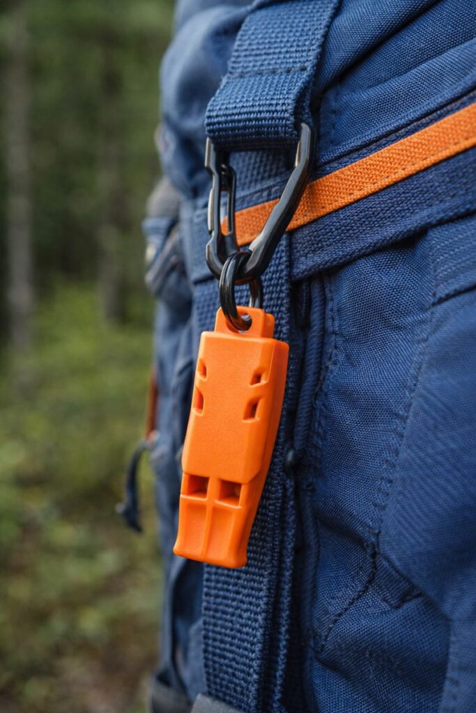 Orange emergency survival whistle for signaling help when lost while camping