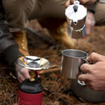 Compact camping stove with fuel canister on outdoor surface - best lightweight backpacking stoves 2025