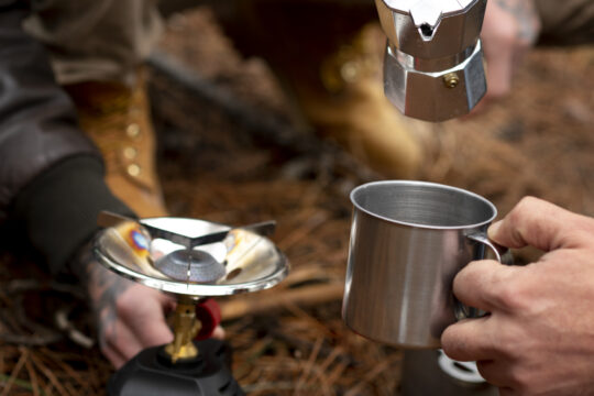 Compact camping stove with fuel canister on outdoor surface - best lightweight backpacking stoves 2025